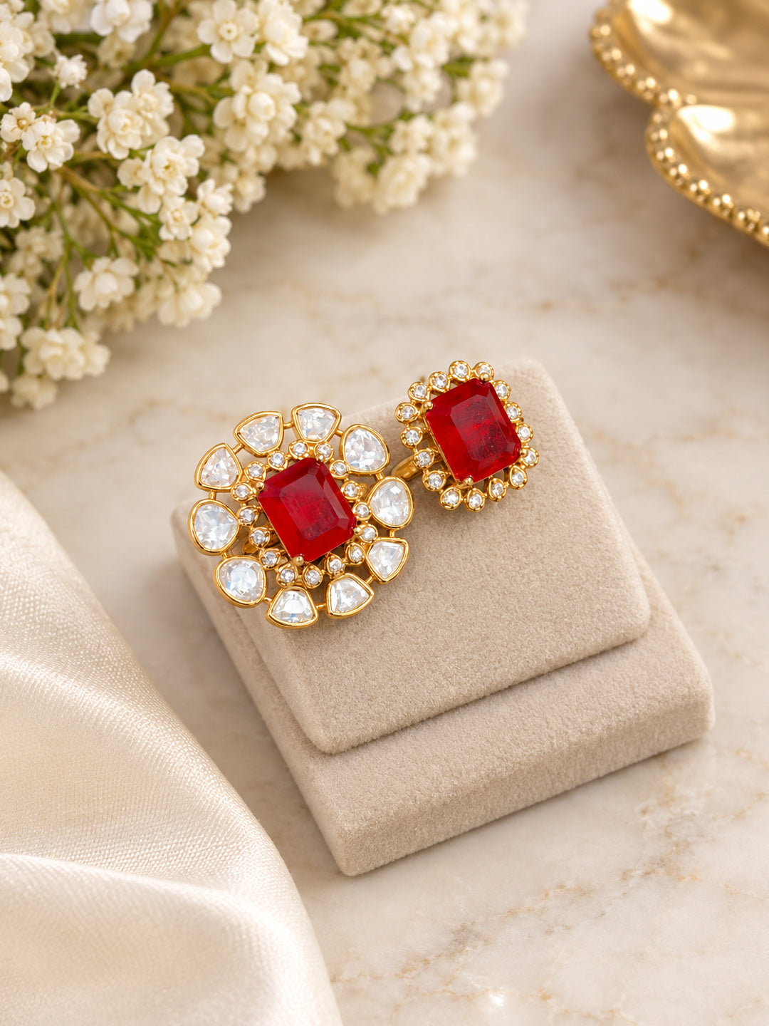 Close-up of Aurveza ruby statement rings with petal-shaped and round halo settings