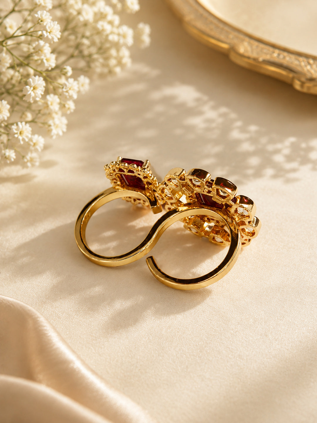Close-up of Aurveza ruby statement rings with petal-shaped and round halo settings