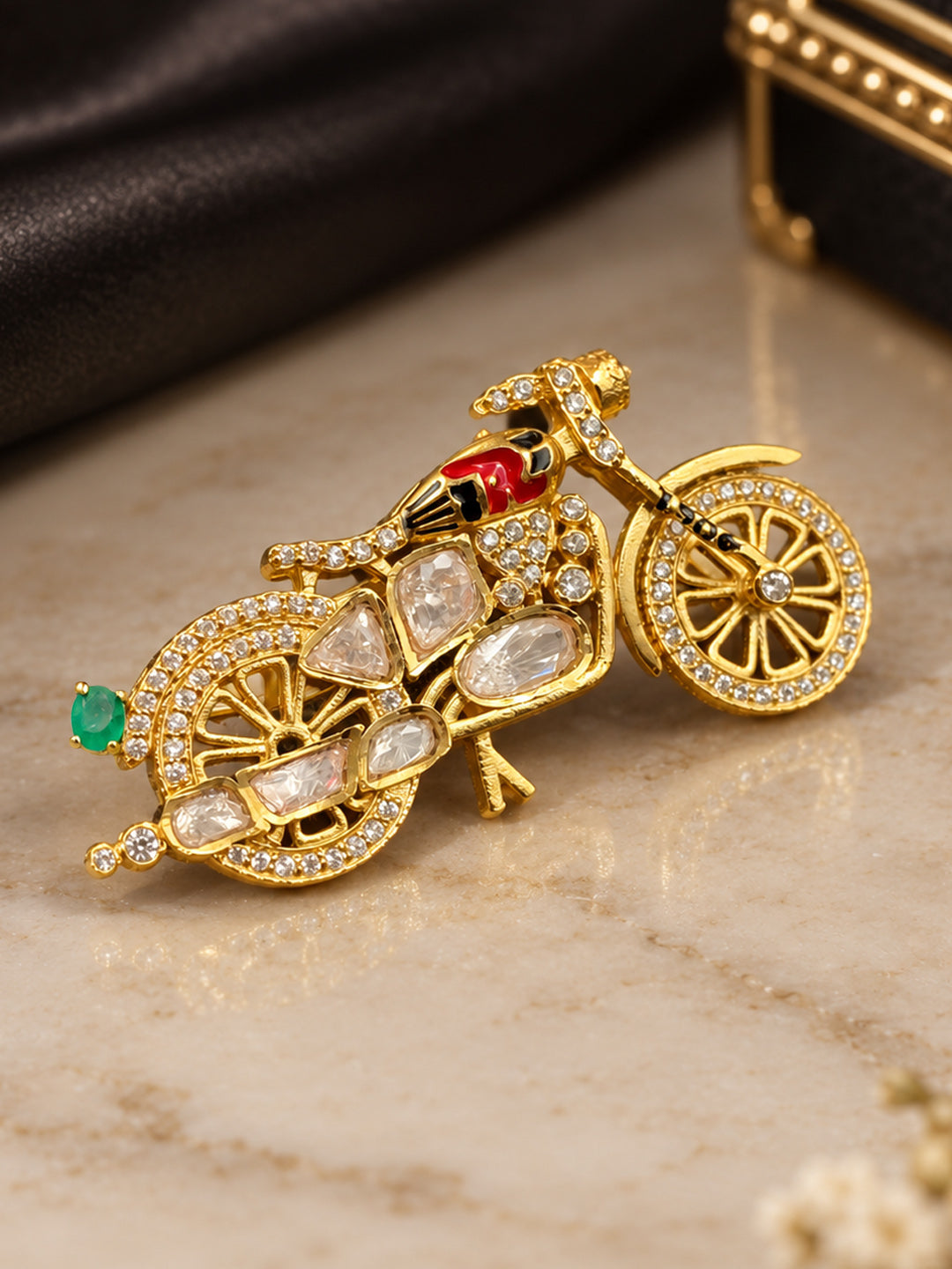 : Polki stone motorcycle brooch featuring red-black enamel rider detail in gold tone